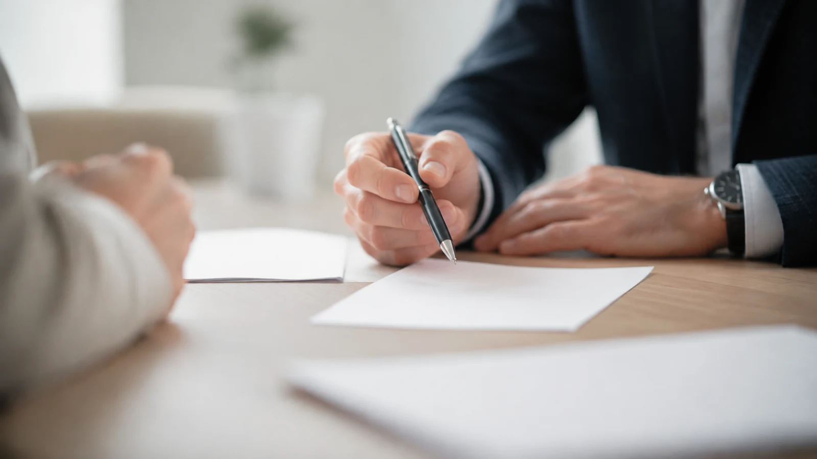 Mains posant un stylo plume sur un bureau